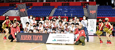 体育館で撮影した、Ｕ12ミニバス選手たちと金子さんの記念写真