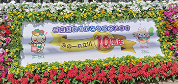 花に囲まれたオープン10周年記念パネル